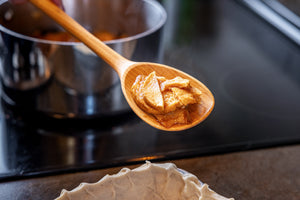 cooking spoon serving apple filling into pie