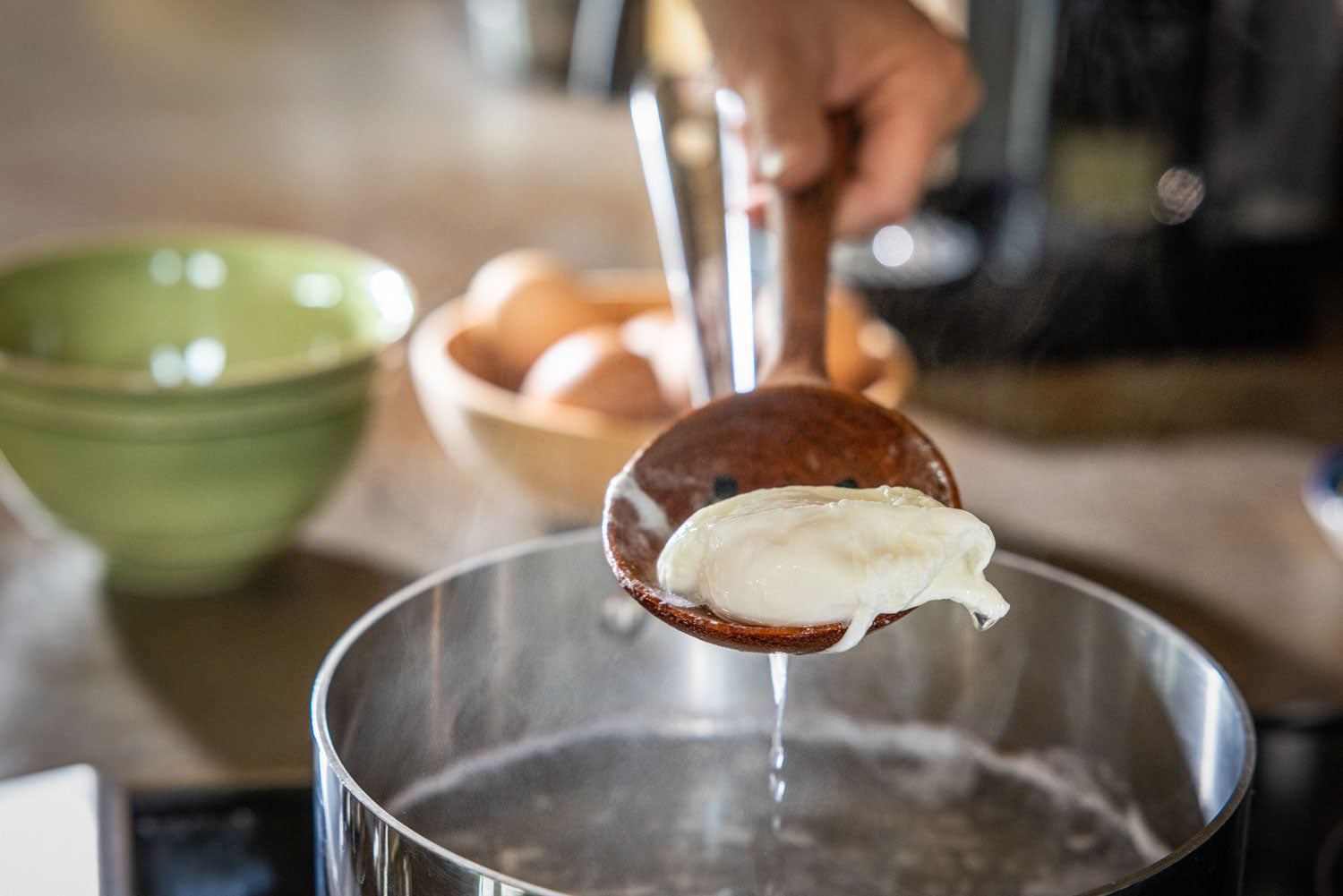 wooden slotted spoon with poached egg