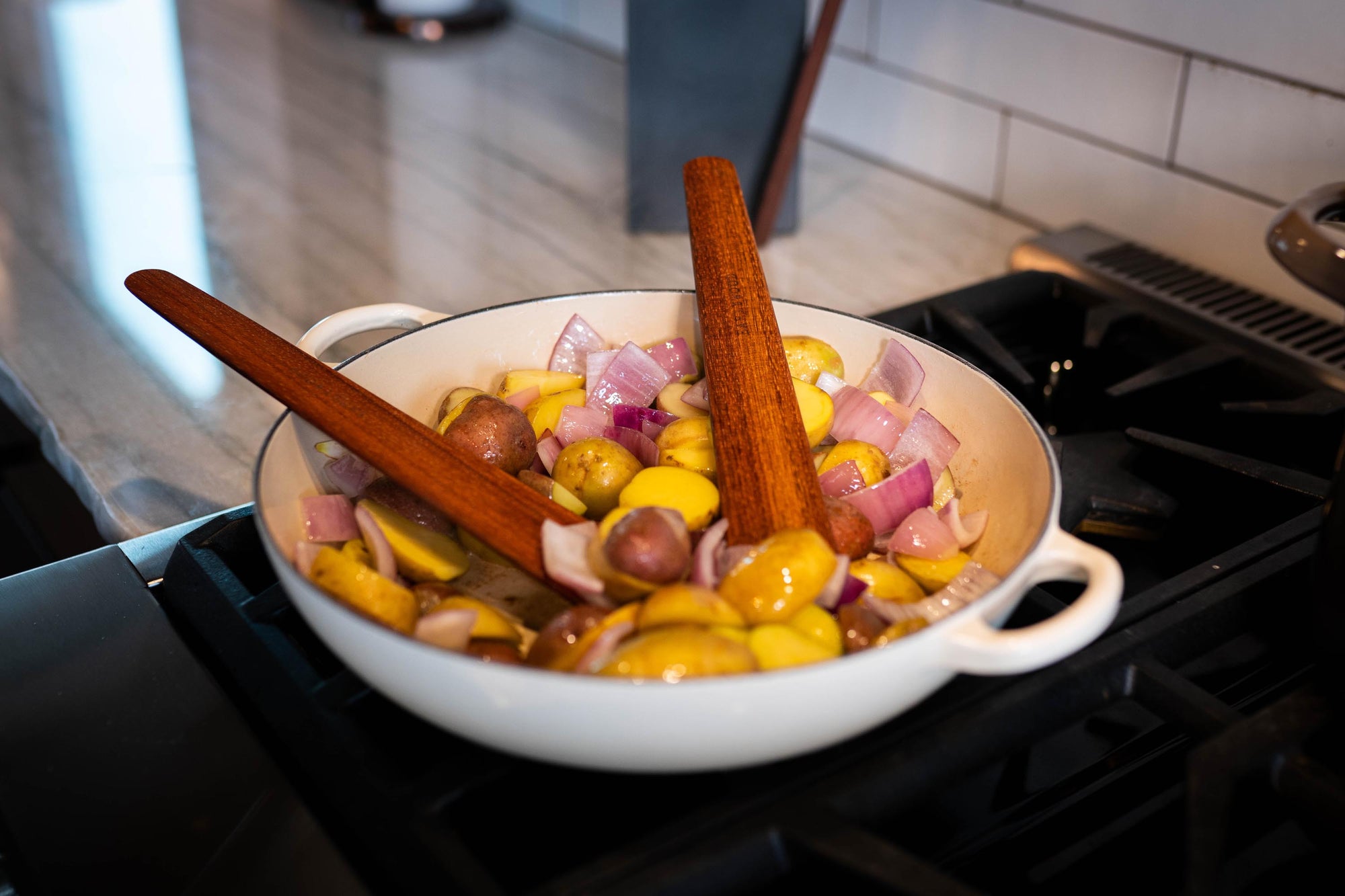 two thin wooden spatulas for cooking in pan on stove - Earlywood