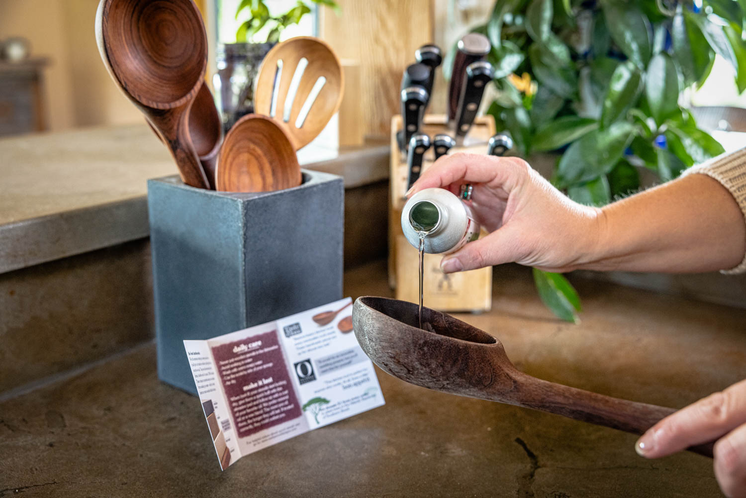 oiling a dry wooden spoon with butcher block oil