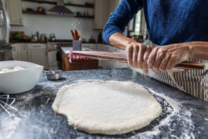 putting flower on wooden rolling pin for baking - earlywood