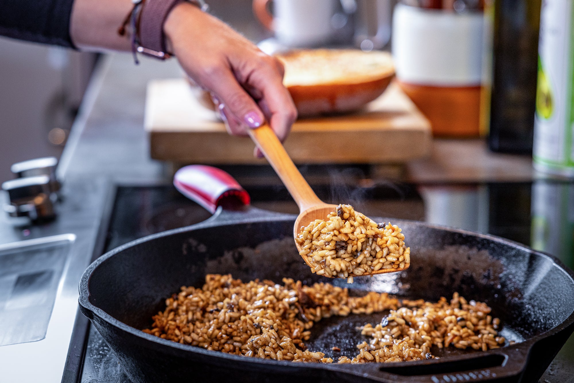 scraper spoon scooping up risotto from cast iron