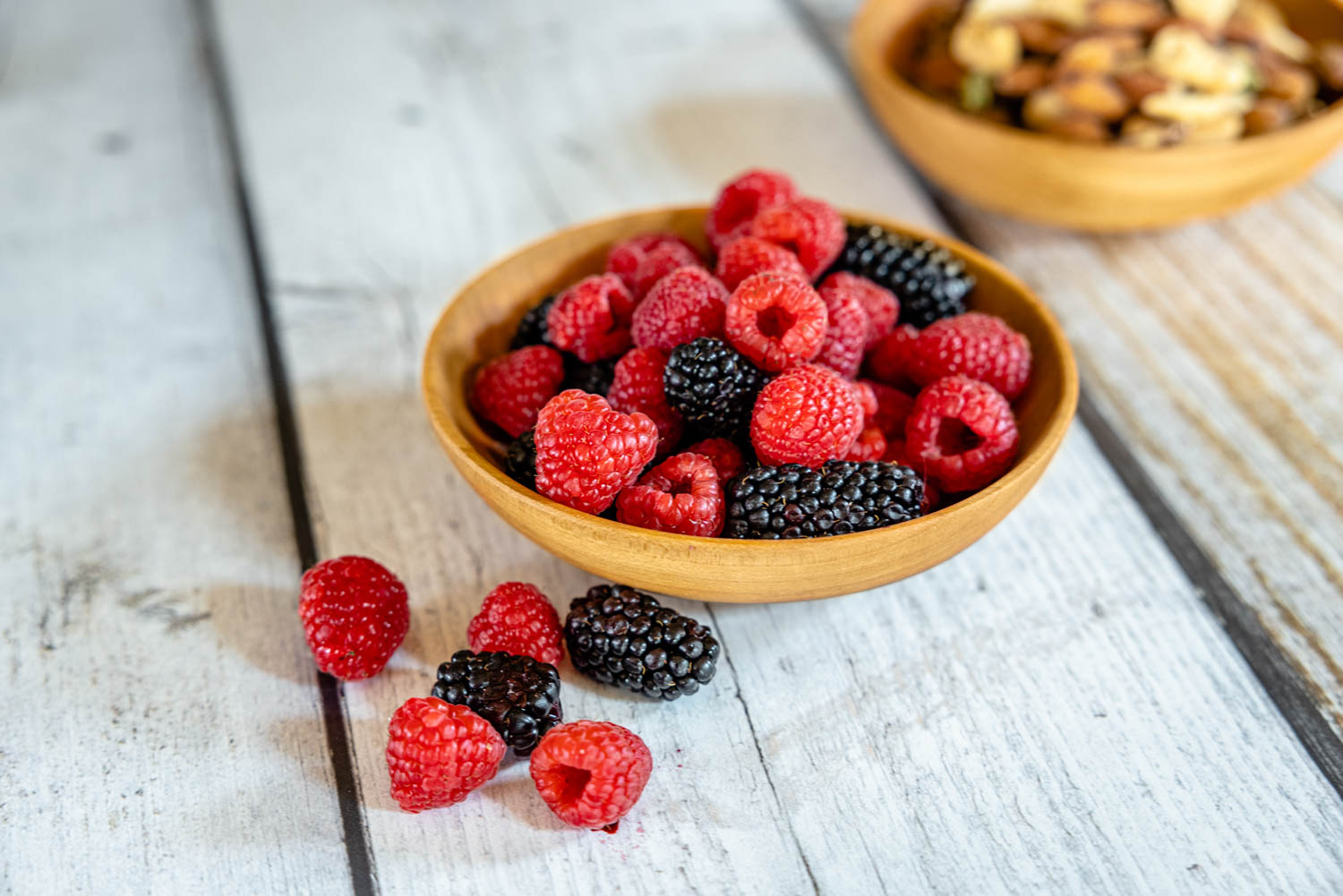 small wooden fruit bowl with berries and nuts