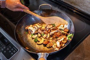 wok spatula moving stirfry around in a wok