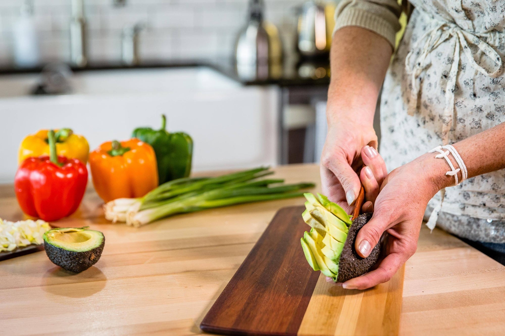 wide blade wooden butter spreader scooping avocado from shell - Earlywood